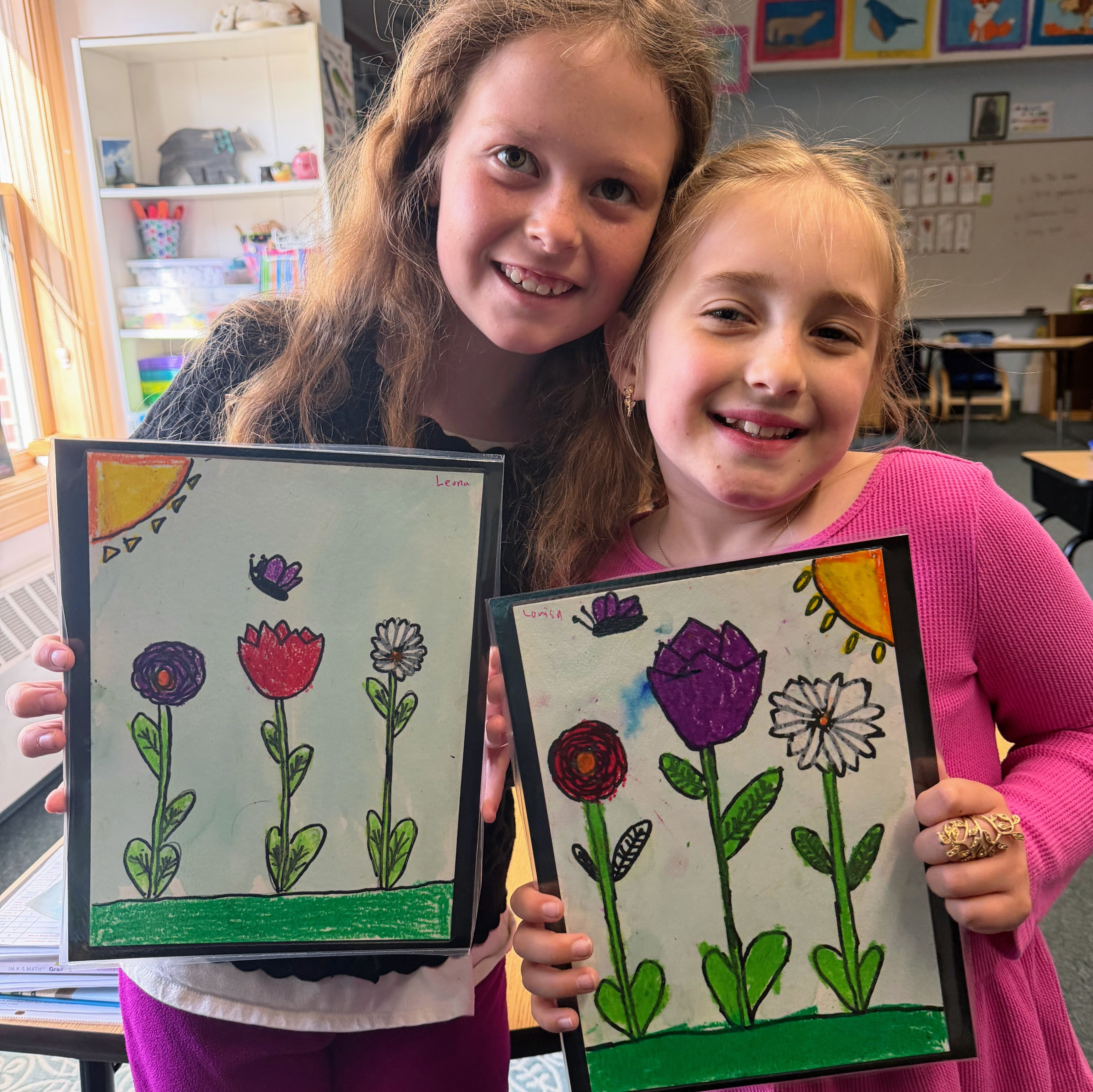 Students hold up work they made for a window display at Children in the Arts. 